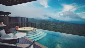 An infinity pool with a wooden deck, outdoor furniture, and a hot tub. - Elevate Bali (Munduk)
