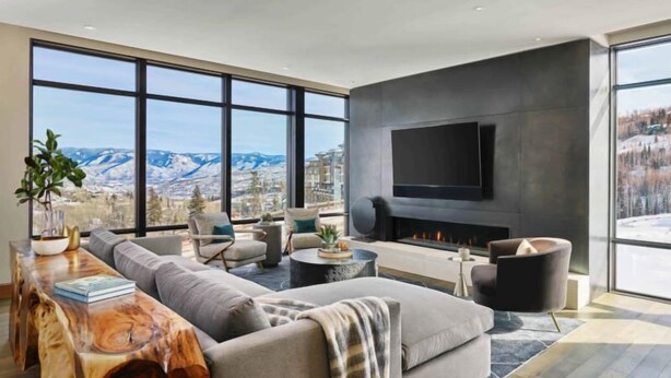 A modern living room with a large window, a fireplace, and a flat-screen TV. - One Snowmass East 307 (Snowmass)