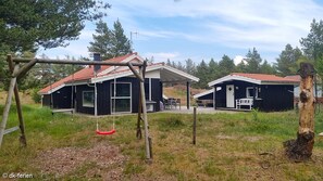 Two cabins nestled among lush greenery, offering a peaceful retreat with comfortable living spaces and a family-friendly atmosphere.