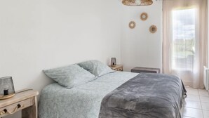 A bedroom with a bed, bedside table, lamp, and decorative wall art. - La Perle de Damgan by Interhome (Damgan)