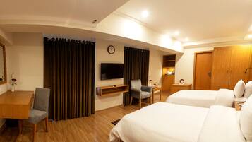 Ein Hotelzimmer mit einem Holztisch, einem Fernseher, einem Bett und einem Sessel.