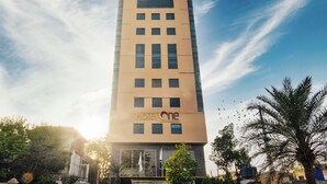 En hög hotellbyggnad med namnet ”Hotel One” på fasaden.