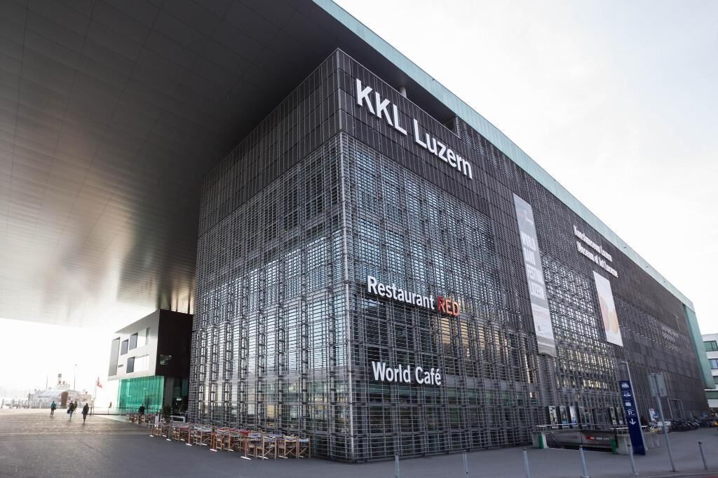 Un edificio moderno con fachada de entramado, con la leyenda "KKL Luzern" y "World Café".