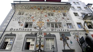 Un edificio con un mural de un árbol y una estatua de un caballero, con el texto 'Sunfibus zu Fristeln'.