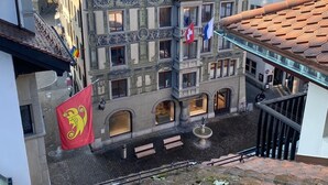 Un edificio histórico con arquitectura ornamentada, varios balcones y banderas.