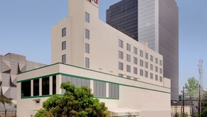 A hotel with a flat facade, multiple windows, and a green trim.