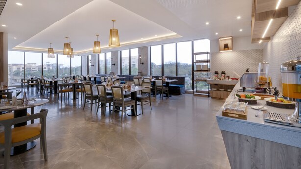 A spacious restaurant with high ceilings, large windows, and a modern interior design.