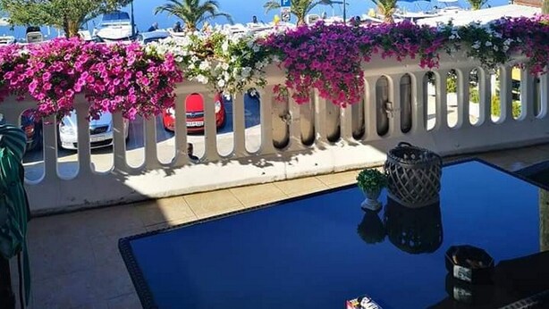 A balcony with a view of a lake, a pool, and boats. - Apartment Marjan (Posedarje)