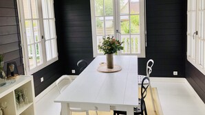 A room with a white table, black walls, and large windows. - COSY house 600 m from the beach, ideal for families - (Agon-Coutainville)
