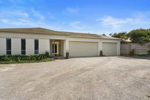 A single-story house with a garage, a driveway, and a small garden area. - Banksia House (Blairgowrie)