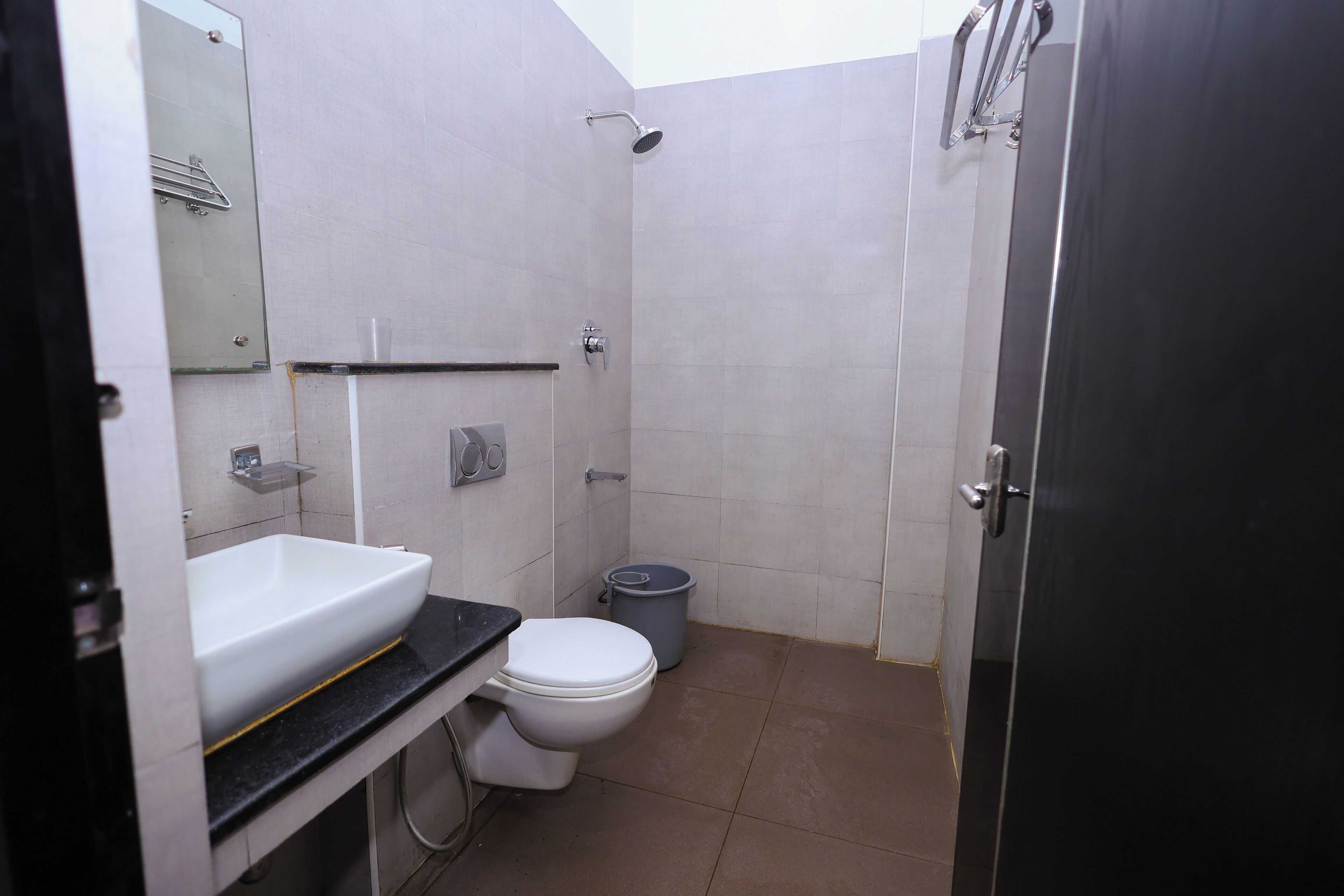 A compact bathroom with a white sink, toilet, and a shower area.