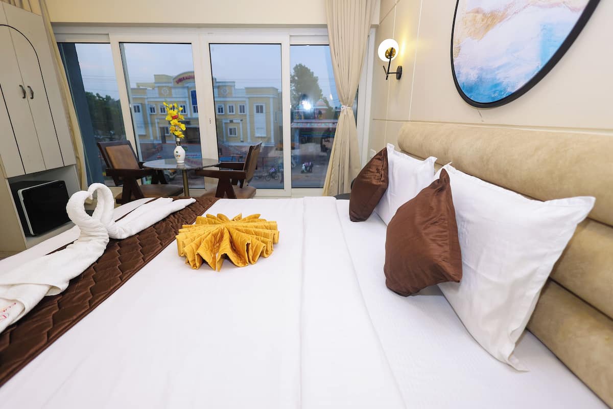 Une chambre d’hôtel avec un lit, une télévision, un bureau et une vue sur l’extérieur.