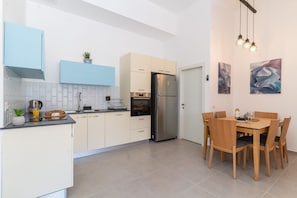 Prepare meals in the fully equipped kitchen with a refrigerator, oven, and coffee station.