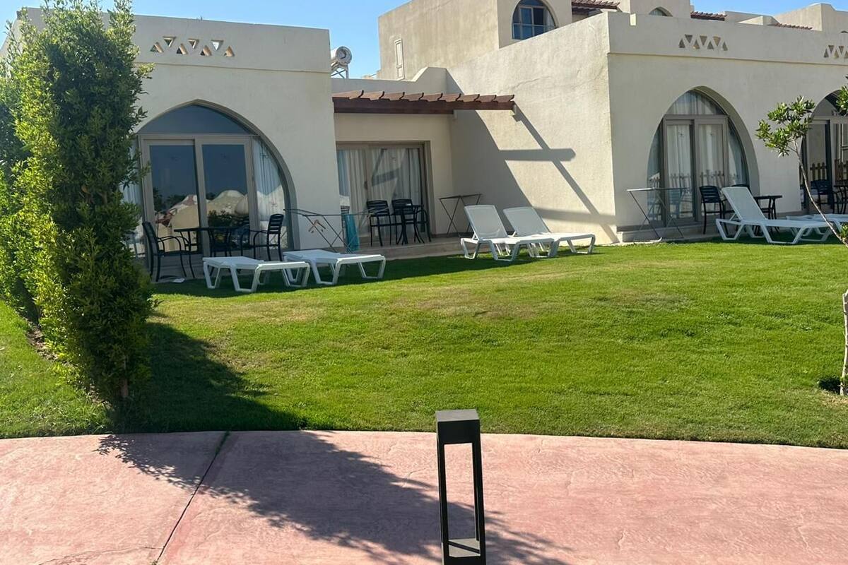 A hotel with a courtyard featuring outdoor seating and a pool area.