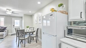 A modern kitchen with a white refrigerator, a built-in oven, and a dining area with a table and chairs. - 2 Mi to Dtwn Gilbert! Snowbird Escape w/ Pool (Gilbert)