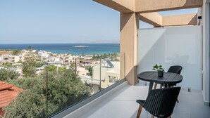 Un balcon avec une table et des chaises, offrant une vue sur le paysage urbain de la côte.