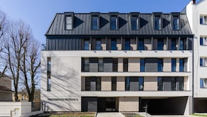Un edificio moderno de varios pisos con techo plano y grandes ventanales.