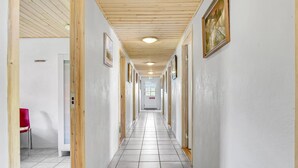 A long, narrow hallway with wooden paneling on the walls and a tiled floor. - Pet friendly apartment in Strynø (Strynø)