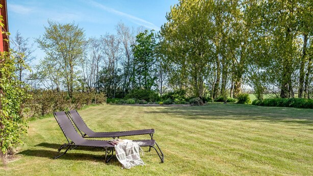 A grassy outdoor area with a lounge chair and a blanket. - Pet friendly apartment in Strynø (Strynø)