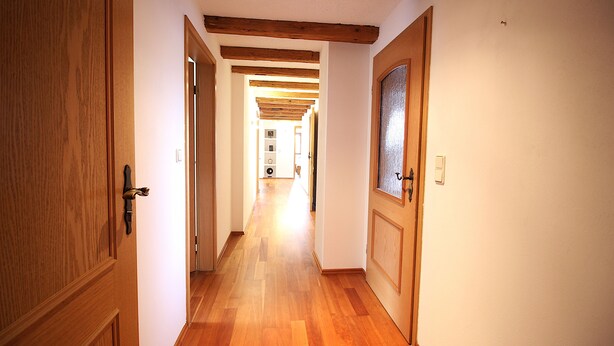 Un couloir avec des portes en bois et un plafond en bois.