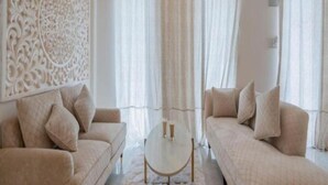 A modern living room with two sofas, a coffee table, and decorative wall paneling. - Lillywoods Zac Beach Resort (Calangute)