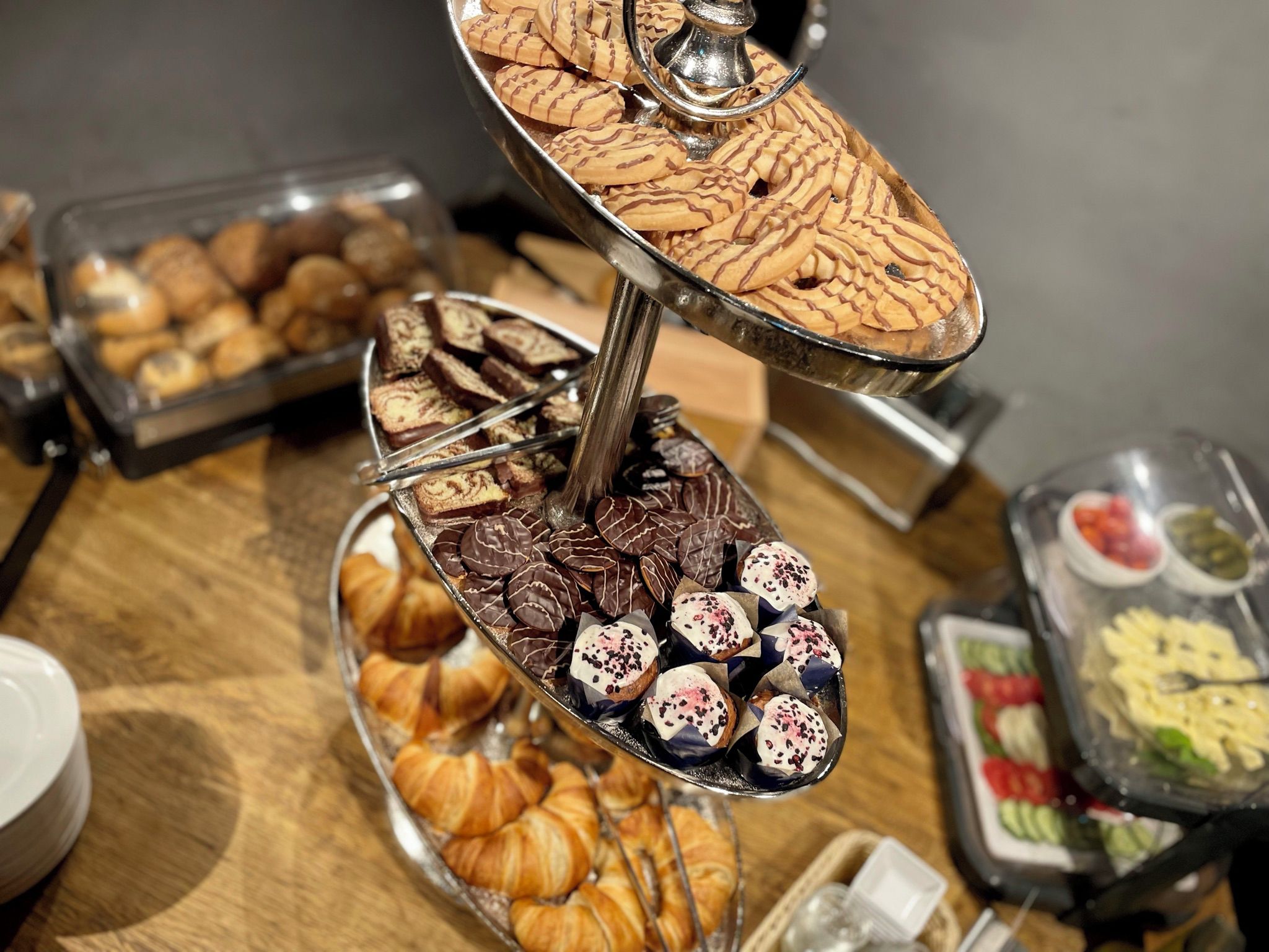 Un soporte de varios niveles con diversos pasteles y chocolates.