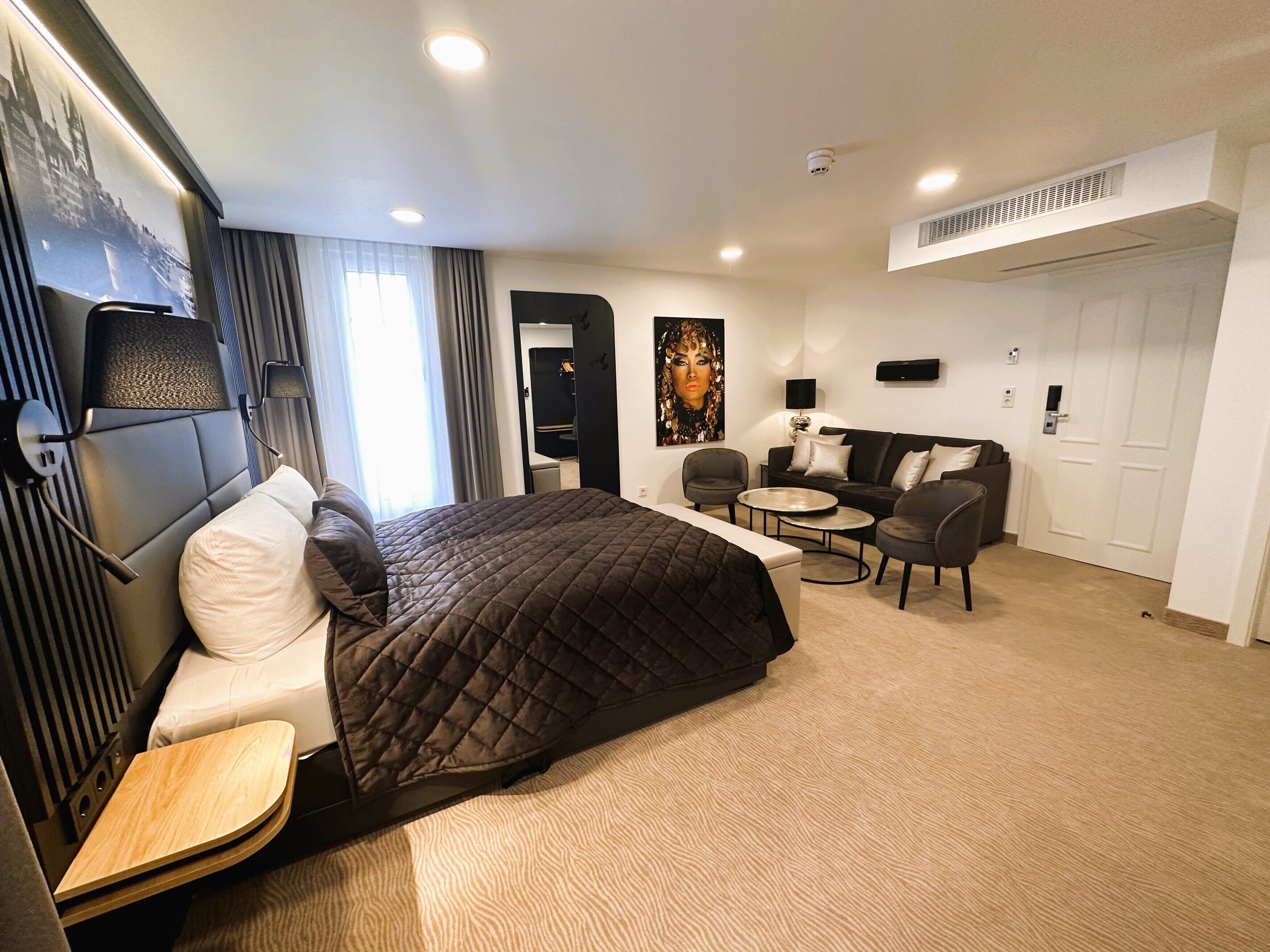 Une chambre d’hôtel avec un lit, un bureau, un canapé et une chaise.