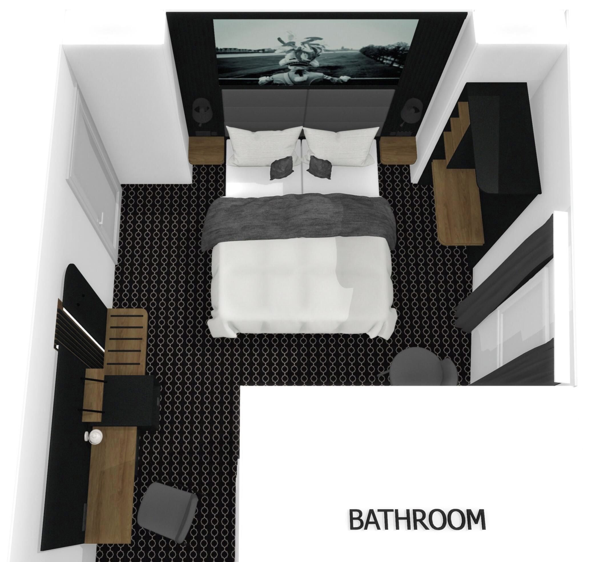 A bathroom with a bed, a small seating area, a mirror, and a toilet.