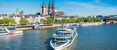 A river with boats, a cathedral, and a stadium.