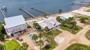 Una propiedad costera con piscina, muelle y zona de playa.