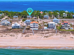 Zona costera con propiedades frente al mar, incluyendo casas con balcones y piscina.