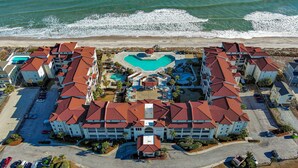 A resort with multiple buildings, a central swimming pool, and a beach view. - 411-B Villa Capriani: Ocean Views & Beach Bliss! (North Topsail Beach)