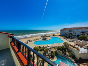 Een resort met een zwembad, strand en uitzicht op de oceaan.