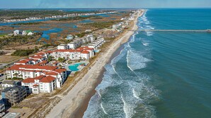 A coastal residential area with beachfront properties, a pier, and a large body of water. - 411-B Villa Capriani: Ocean Views & Beach Bliss! (North Topsail Beach)
