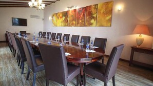 A conference room with a long table, chairs, water bottles, and a television. - Stay.Plus Hurlingham B&B Suite (Nairobi)