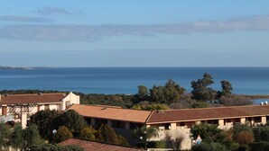A coastal building with a tiled roof, surrounded by trees and overlooking the sea. - Tanca Manna three bedrooms apartment 3 bedrooms 2 bathrooms large sea view (Cannigione)