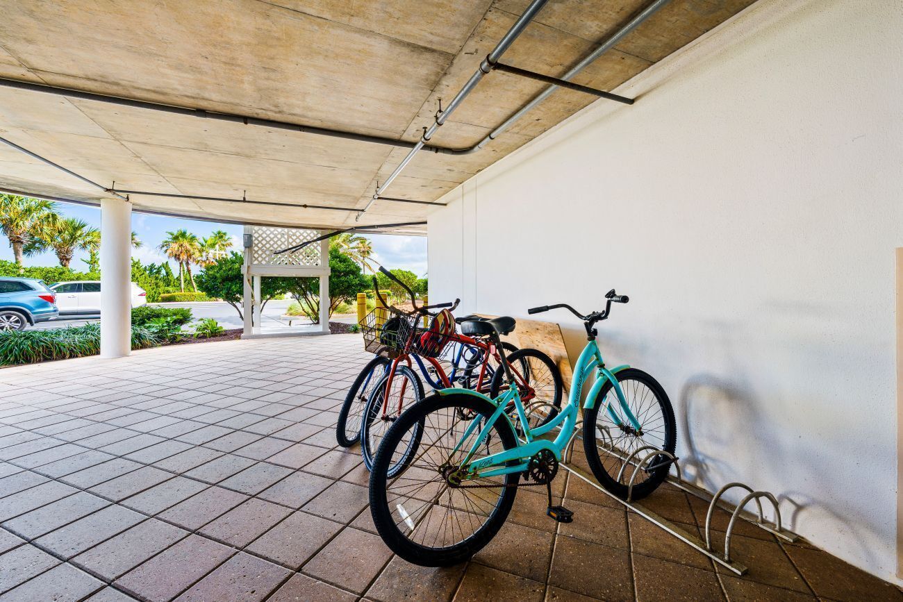 A covered parking area with bicycles and a car.