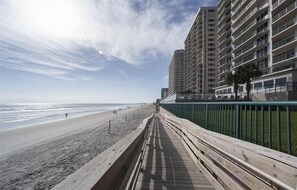 A wooden boardwalk along a beach with high-rise buildings in the background. - 606 DTT - 2 Oceanfront  Primaries (Daytona Beach Shores)