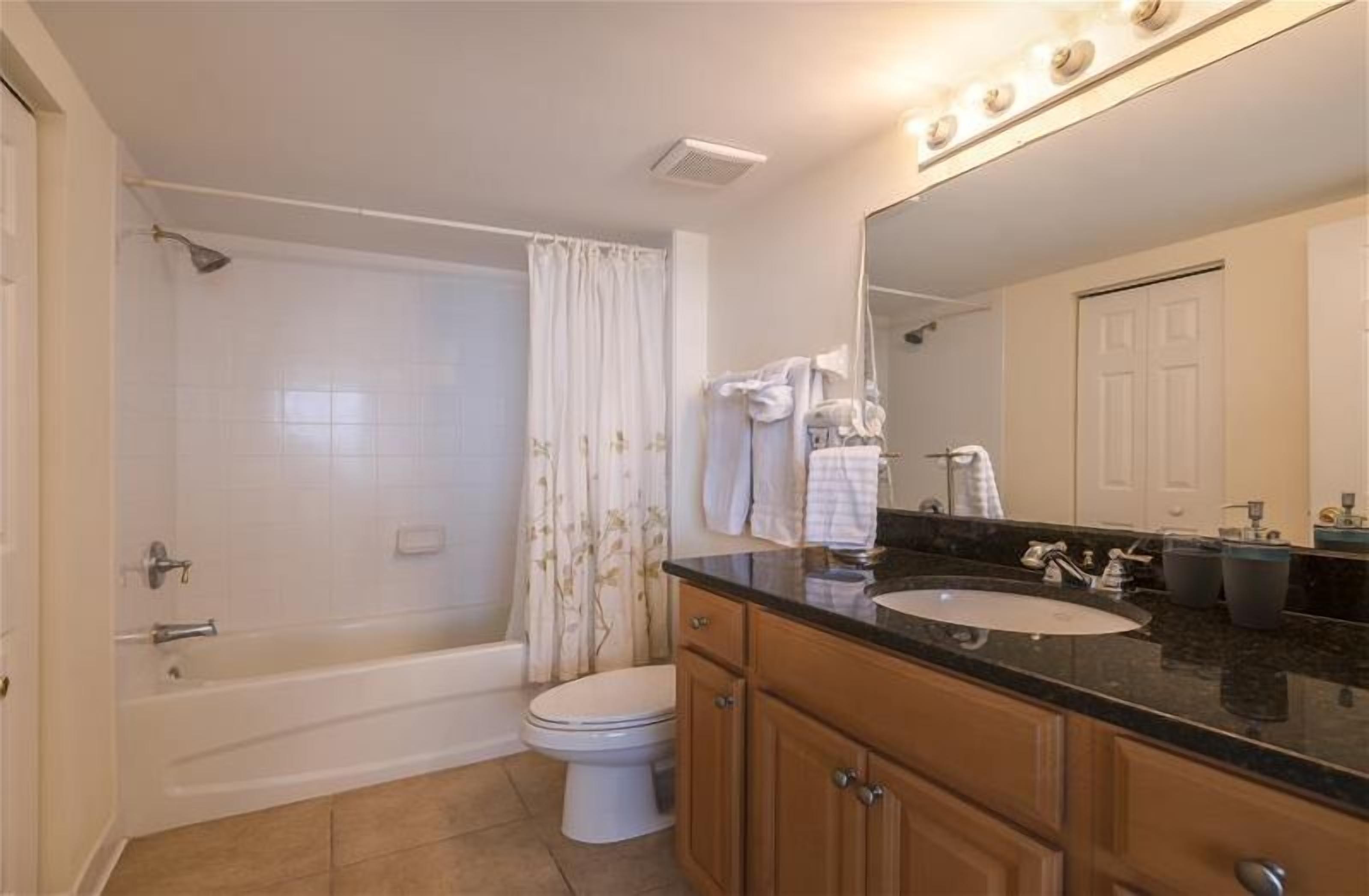 A bathroom with a bathtub, toilet, and sink.
