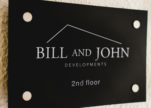 A sign with the text "BILL AND JOHN DEVELOPMENTS 2nd floor". - Acropolis White Key Residence (Athens)