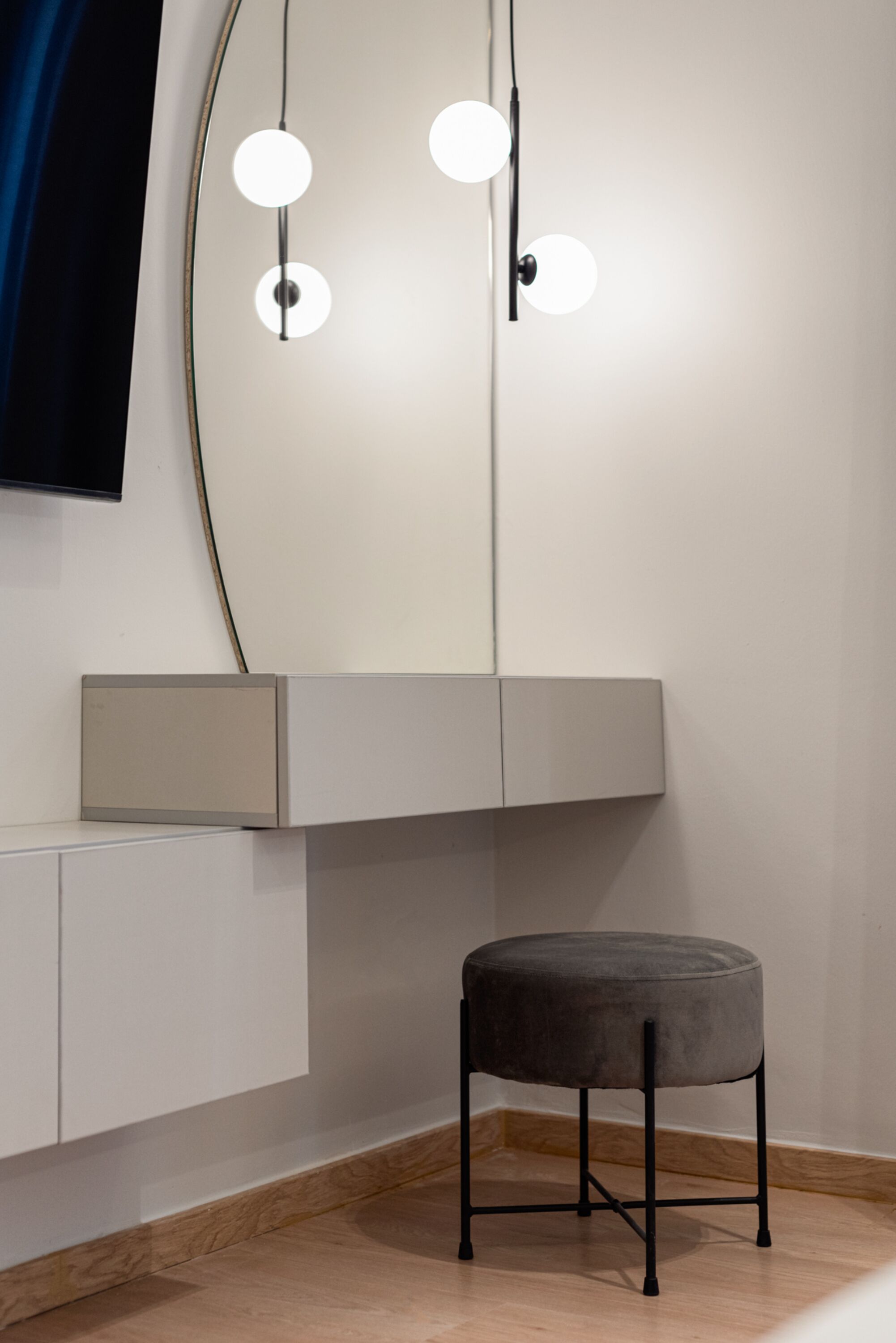 Une salle de bain moderne avec un grand miroir, un meuble-lavabo doté d’un éclairage et un tabouret.