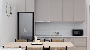 A modern kitchen with a built-in refrigerator, a microwave, and a sink. - Acropolis White Key Residence (Athens)