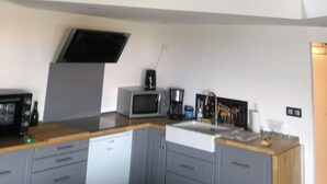Uma cozinha moderna com micro-ondas, cafeteira e torradeira na bancada.