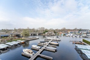 Boats dock at the marina, adjacent to a bridge and nearby buildings.