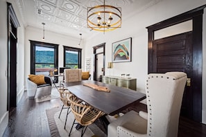 Enjoy meals in a serene space with a view of the surrounding mountains, surrounded by classic chairs and a stylish chandelier.