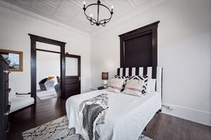 Classic bedroom with a large bed, dark headboard, and patterned throw blanket.