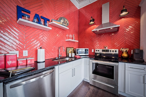 Enjoy cooking in this well-equipped kitchen with a stove, oven, and microwave, plus ample storage in the white cabinets.