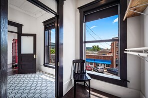 Enjoy a view of the street from this corner room, featuring a large window and a stylish black-framed door.