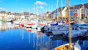 A marina with various boats docked, surrounded by colorful buildings. - Cottage in Plougasnou near Stunning Beaches (Plougasnou)
