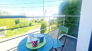 A balcony with a table set for two, featuring a pitcher, two mugs, and a green placemat. - Cottage in Plougasnou near Stunning Beaches (Plougasnou)